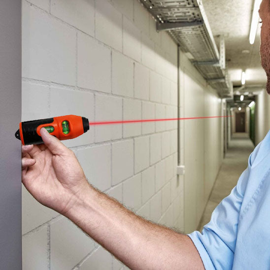 homme utilisant niveau a main dans un couloir blanc