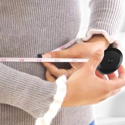 Femme mesure son tour de taille avec le Mètre ruban Règle tailleur 