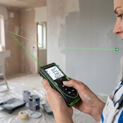 Femme peintre calcul ses mesures avec Télémètre laser Professionnel Vert
